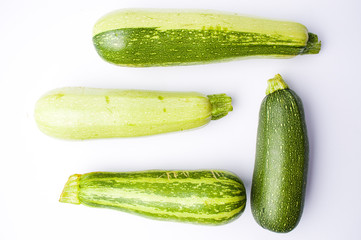 Zucchini, green summer squash on white