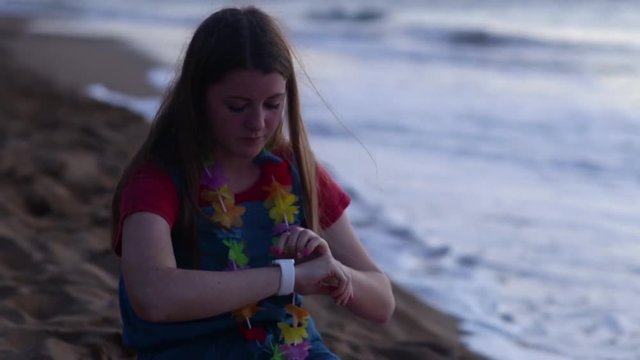 Teen Girl Uses Her Smartwatch On Beach At Sunset, Maui, Hawaii (Slow Motion)
