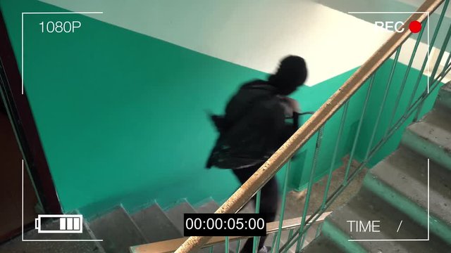 surveillance camera caught the robber in a mask running off with a bag of loot.