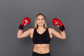 Strong female boxer showing muscles