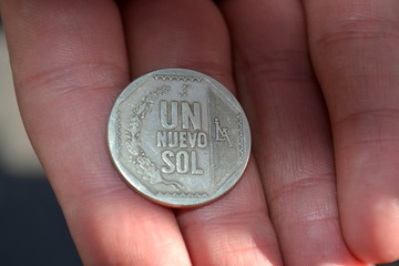 un nuevo sol monnaie du pérou dans une main 