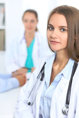 Happy doctor woman  with medical staff at the hospital sitting at the table