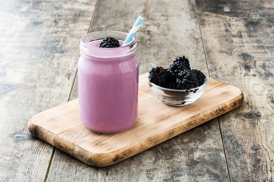 Healthy blackberry smoothie in glass on wooden table
