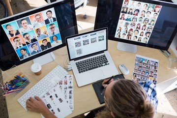 Male executive working over laptop and graphic tablet at his des