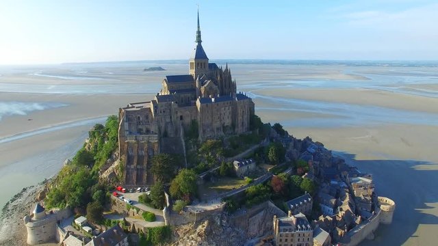 Aerial view of Mont Saint Michel, famous island and monastery protected by UNESCO at twilight, Normandy, France, 4k UHD 