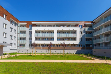 Modern residential building under clear blue sky, green lawn in front