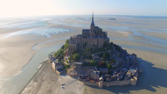 Aerial view of Mont Saint Michel, famous island and monastery protected by UNESCO at twilight, Normandy, France, 4k UHD 