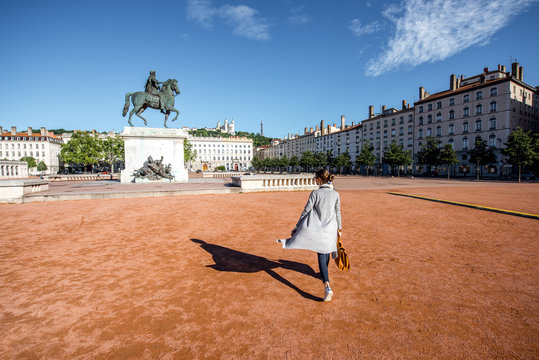 Woman walking on the famous Bellecour square with Louis king statue traveling in Lyon city in France