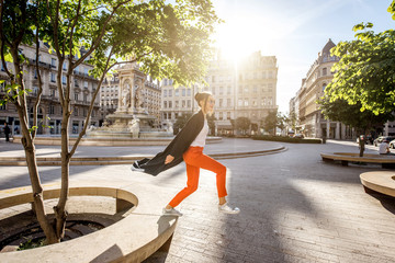 Lifestyle portrait of a stylish woman jumping on the Jacobins square in Lyon city