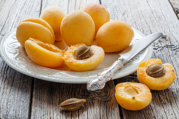 crowd of ripe apricots on white wooden background.