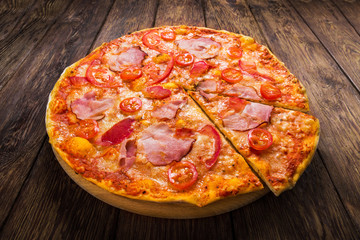 Delicious pizza with ham on wood