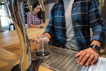 Midsection of bartender preparing drink