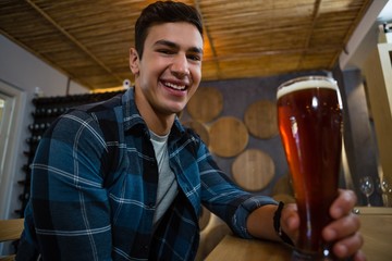 Portrait of happy man holding beer glass