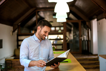 Portrait of a smiling bearded man reading book