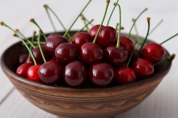 Sweet fresh cherries on white wood background