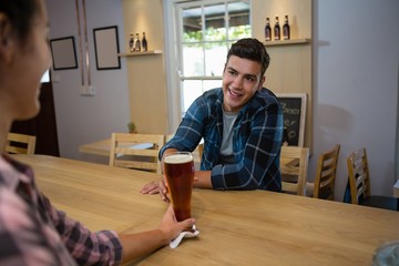Bartender serving drink to man