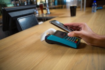 Cropped hand of customer making contactless payment