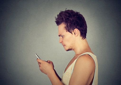 Furious man watching apps on smart phone