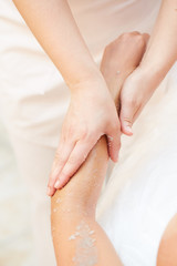 Naklejka premium Woman Getting a Salt Scrub Beauty Treatment in the Health Spa