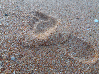 Natural background of human footprint in the wet sandy seaside. Close-up photography on relaxation sign idea design