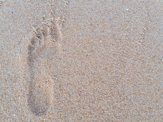 Natural background of human footprint in the wet sandy seaside. Close-up photography on relaxation sign idea design