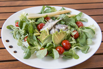 Ensalada de canónigos, con aguacates, sardinas y tomate