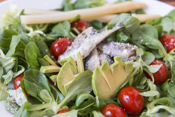 Ensalada de canónigos, con aguacates, sardinas y tomate