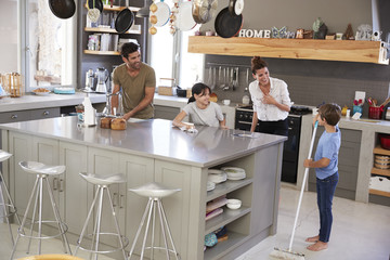 Children Helping Parents With Domestic Chores In Kitchen - Powered by Adobe