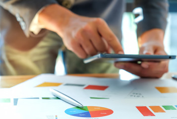 Fototapeta premium Businessmen are analyzing graphs and using tablets.