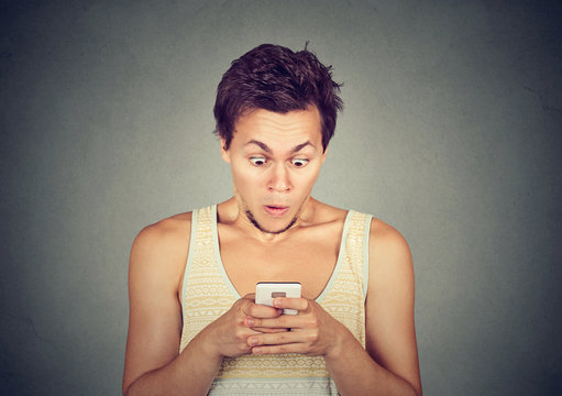 Shocked man reading text message or news on mobile phone
