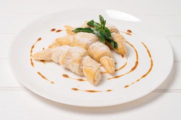 Croissant with brie cheese and jam on white plate