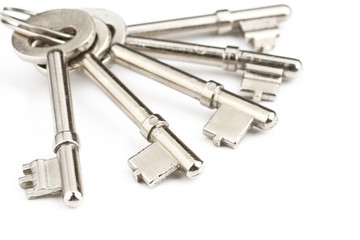 Old silver-color metal keys with key chain on white background