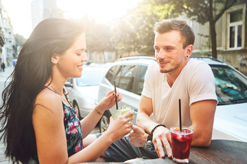 Young couple sitting at cafe and having fun