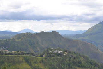 Obraz premium Green mountains under white clouds
