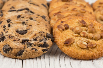 Biscuits with chocolate and peanut on old wooden table.