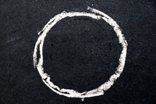 White chalk drawing as circle shape on black board background (Use for decoration, bubble speech, rubber stamp)