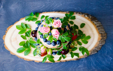 Naked wedding cake decorated with berries and flowers