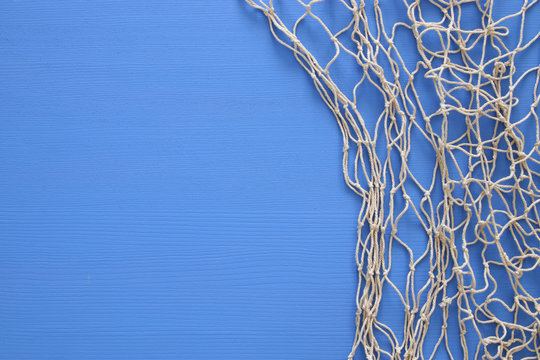 Top view of Fishnet on blue wooden background