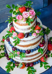 Obraz na płótnie Canvas Naked wedding cake decorated with berries and flowers