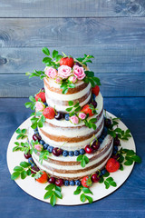 Naked wedding cake decorated with berries and flowers