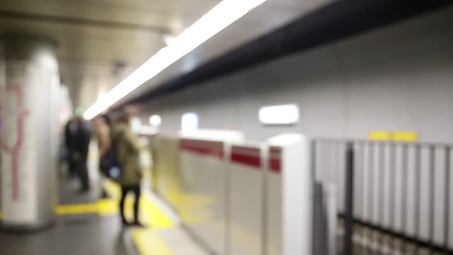 Tokyo metro train stops at a platform and passengers embark and disembark