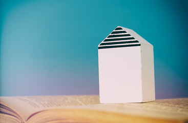 small house model over open book. selective focus
