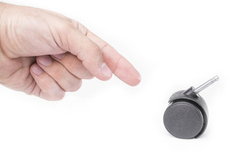 Hand points to a plastic furniture wheel isolated on a white background