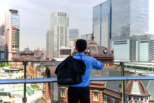 Business man take photo of Tokyo station
