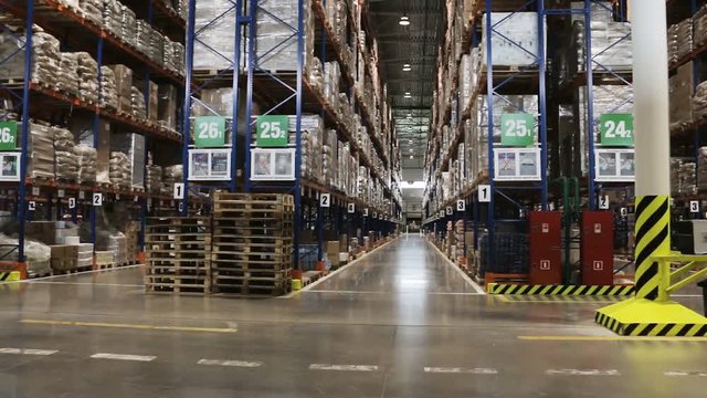 Slow pan of typical retail distribution center - warehouse interior - shelves, racks, stacks.