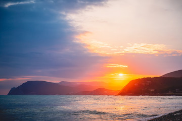 Warm sunset or sunrise on ocean and mountains