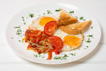 Plate of breakfast with fried eggs, bacon and toasts isolated on white background