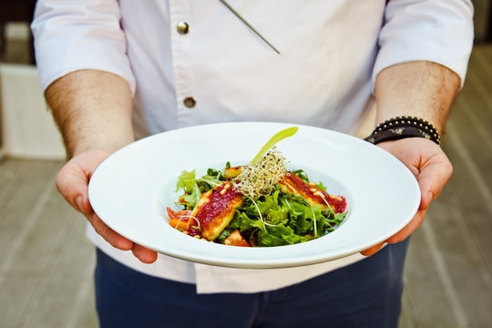 Beautiful fresh Salad with halloumi cheese grilled in the hands of the chefs are men