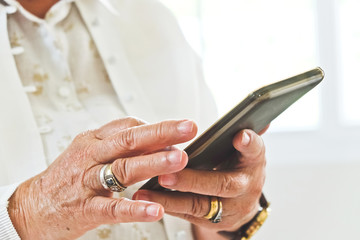 close up image of Senior woman using her mobile phone background.  An idea of modern lifestyle, communication,telecommunication,connectivity, social networking