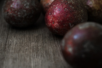 Red passion fruits on old wood background.